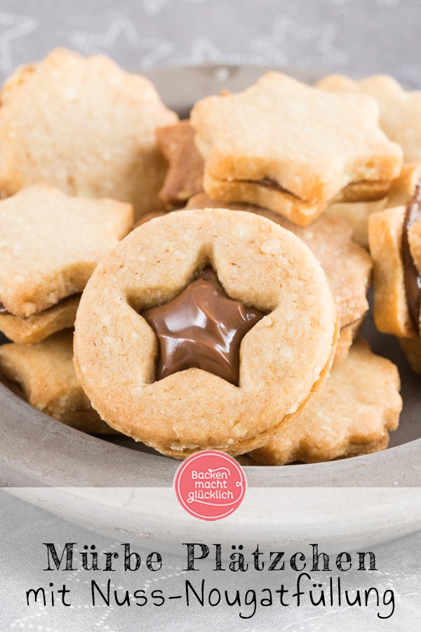 Nuss-Nougat-Plätzchen - mürbe und knusprige Kekse, dazu feines Nougat, das ganze aromatisiert mit etwas Cappuccino. Rein optisch erinnern die Nuss-Nougat-Plätzchen ein wenig an Omas Spitzbuben, der Geschmack geht aber in eine völlig andere Richtung: Richtig schön schokoladig und nussig sind die gefüllten Nougatplätzchen.