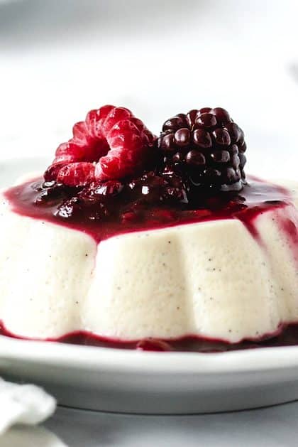 Panna Cotta gestürzt mit Beerensoße, Himbeere und Brombeere garniert