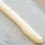 Aufgerollter Hefeteig auf bemehlter Silikon-Backmatte