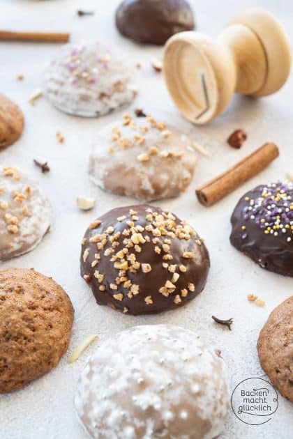Lebkuchen mit Schokolade, Zuckerguss und Nüssen bestreut, Zimtstangen daneben