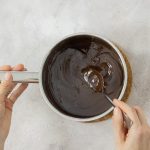 Geschmolzene Schokolade wird im Topf für Mousse au Chocolat verrührt