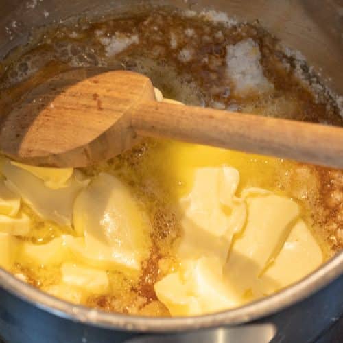 Butterstücke schmelzen im Topf mit Kochlöffel für Karamell-Aufstrich