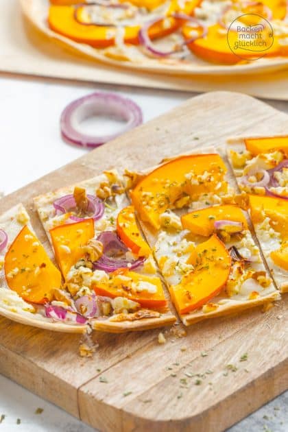 Kürbis-Flammkuchen mit roten Zwiebeln und Walnüssen, in Stücke geschnitten