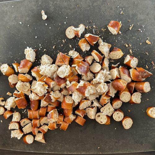 Gewürfelte Laugenbrezeln auf dunklem Schneidebrett vor dem Backen