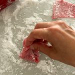 Rosa Mochi-Teig wird auf bemehlter Arbeitsfläche zu Kügelchen geformt