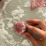 Rosa Mochi-Teigkugel wird in Speisestärke geformt
