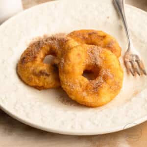 Ausgebackene Apfelküchle mit Zimtzucker auf Teller