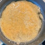 Karamell brutzelt goldbraun schäumend in Pfanne für Tarte Tatin