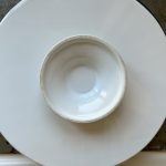 Leere weiße Schüssel auf runder Platte für Tarte Tatin vorbereitet