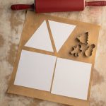 Papierschablonen für Lebkuchenhaus mit Nudelholz und Weihnachtsausstechformen