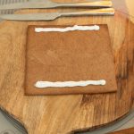 Lebkuchenplatte mit zwei Zuckergussstreifen als Klebeleisten auf Holzbrett