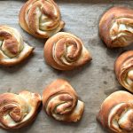 Frisch gebackene Splitterbrötchen mit gerollter Struktur auf Backpapier