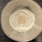 Mehl mit Hefewasser in Metallschüssel für Splitterbrötchenteig