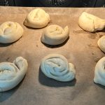 Rohe Splitterbrötchen aus Hefeteig auf Backpapier vor dem Backen