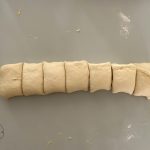 Hefeteigrolle in gleichmäßige Stücke geschnitten für Splitterbrötchen