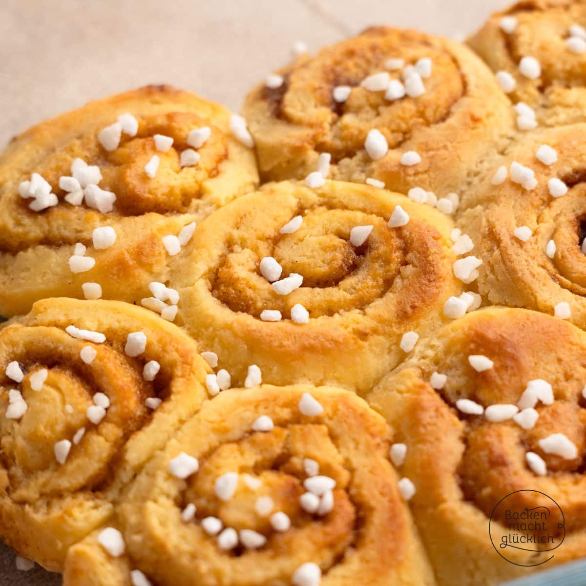 Frisch gebackene Zimtschnecken mit Zimtspiralen und Hagelzucker bestreut