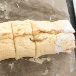 Zimtschnecken-Teigrolle in Stücke geschnitten auf bemehlter Fläche