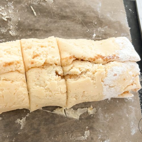 Zimtschnecken-Teigrolle in Stücke geschnitten auf bemehlter Fläche