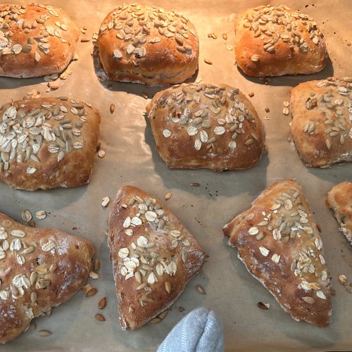 Frisch gebackene Müslibrötchen mit Haferflocken auf Backpapier