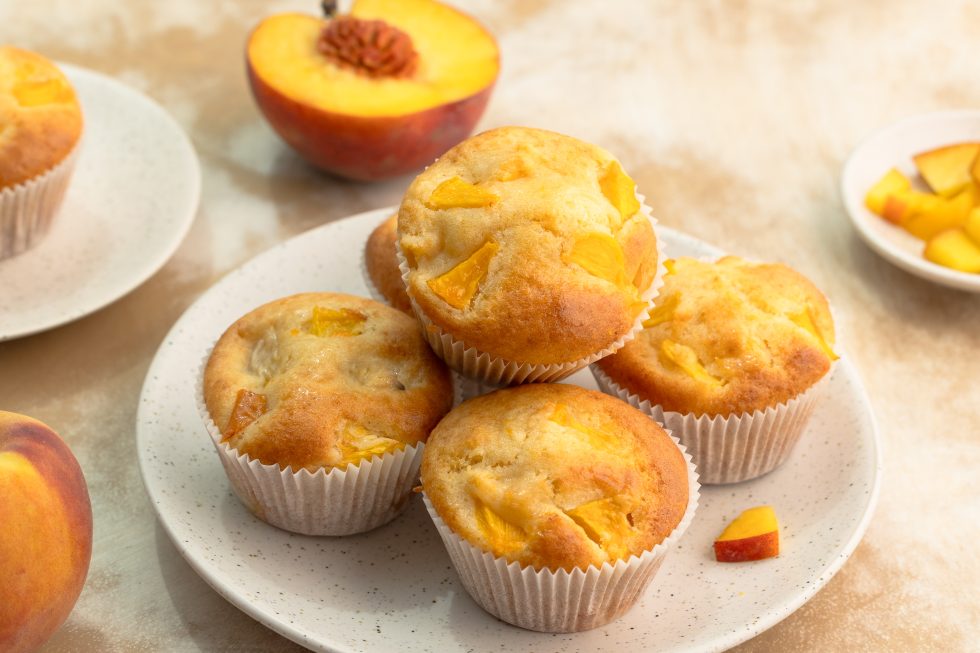 ein Teller frisch gebackener Pfirsichmuffins