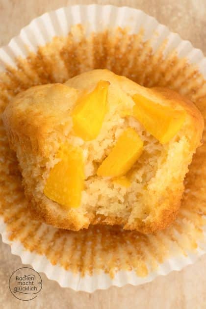 ein angebissener Pfirsich-Muffins mit sichtbaren Pfirsich-Stückchen