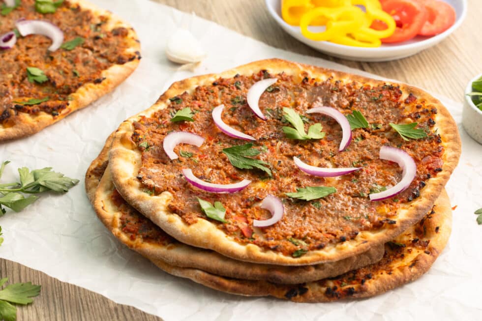 Mehrere Fladen selber gemachte türkische Pizza mit Zwiebeln und Petersilie