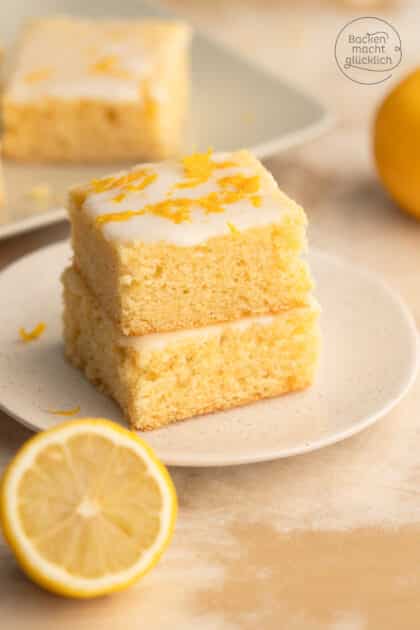 zwei Stücke Zitronenkuchen vom Blech mit frischem Zitronensaft